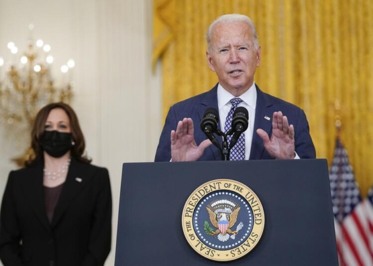 President Joe Biden speaks about the evacuation of American citizens, their families, SIV applicants and vulnerable Afghans in the East Room of the White House, Friday, Aug. 20, 2021, in Washington. Vice President Kamala Harris listens at left.