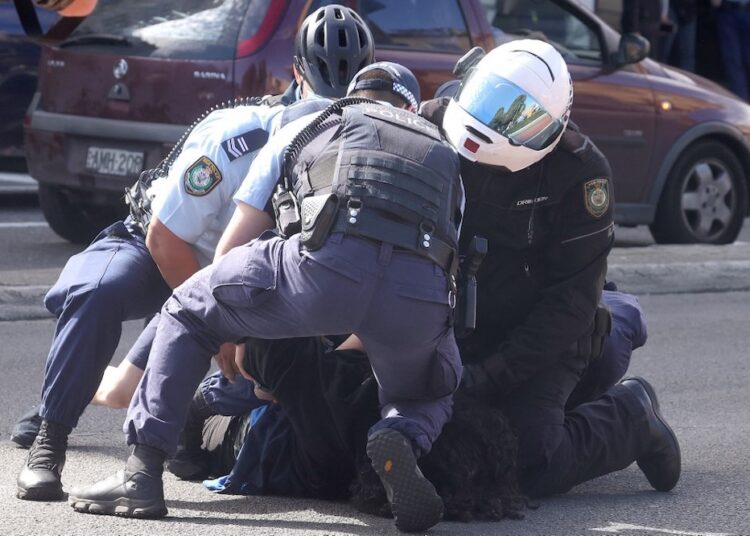 Police officers detain a protestor in Sydney yesterday, following calls for an anti-lockdown protest rally amid a fast-spreading coronavirus outbreak.