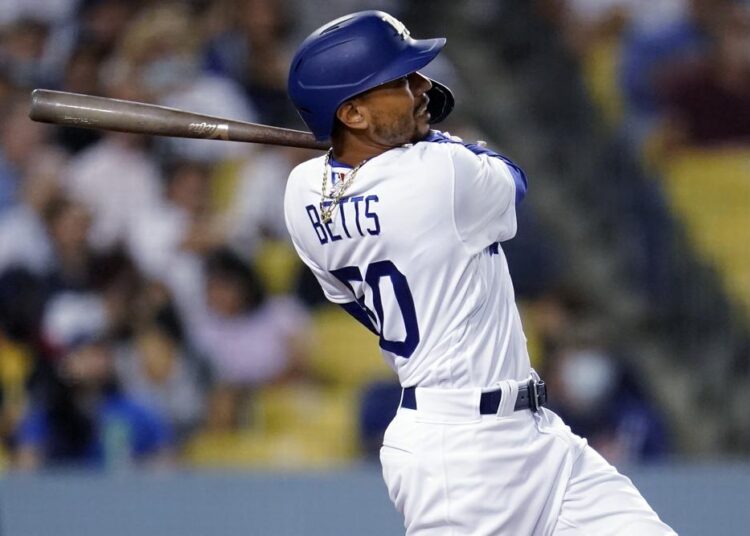 Los Angeles Dodgers' Mookie Betts watches his solo home run during the fourth inning against the Atlanta Braves in a baseball game.
