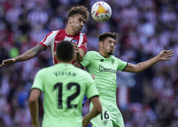 Atletico Madrid's Antoine Griezmann (L) heads the ball past Athletic Bilbao's Unai Vencedor during their La Liga match in Madrid.