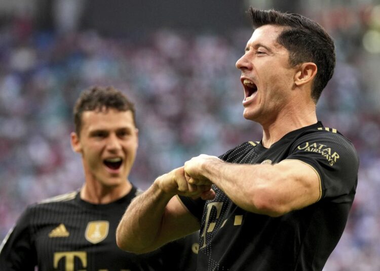 Bayern's Robert Lewandowski (R) celebrates after scoring the first goal of the match, on a penalty, during the German Bundesliga match in Leipzig, Germany.