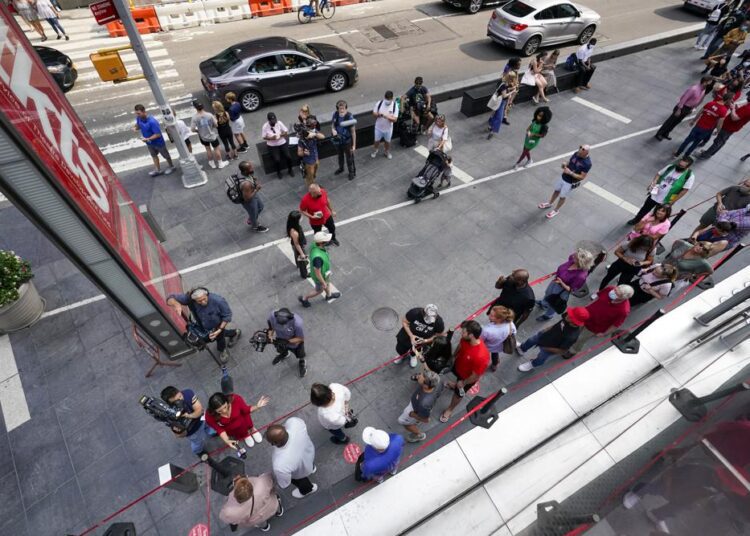 A television crew interviews the first people in line to buy discounted Broadway show tickets at TKTS, Tuesday, Sept. 14, 2021, in New York's Times Square. A recurring debate among theater lovers has been what event constitutes the proper mark of Broadway's return after the global pandemic. For the producers of three powerhouse shows — "The Lion King," "Hamilton" and "Wicked" — the answer is Tuesday, when the anchors of modern Broadway's success rev their engines again.