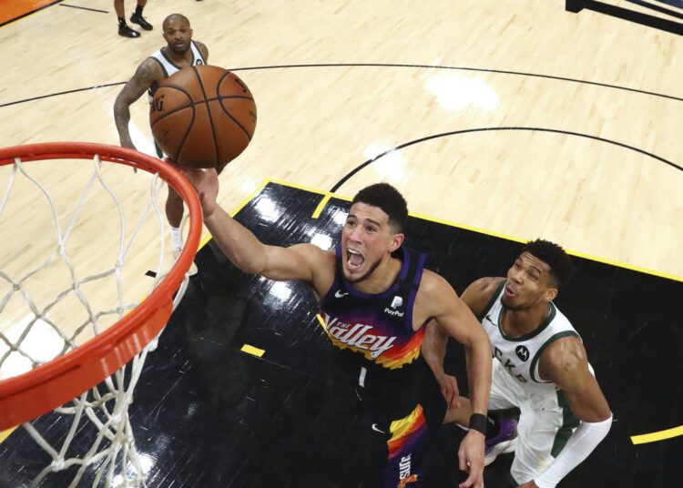 Suns' Booker will miss start of camp due to health protocols 1 - Egyptian Gazette Phoenix Suns guard Devin Booker (1) shoots past Milwaukee Bucks Giannis Antetokounmpo during the NBA Finals, in Phoenix on July 17, 2021.