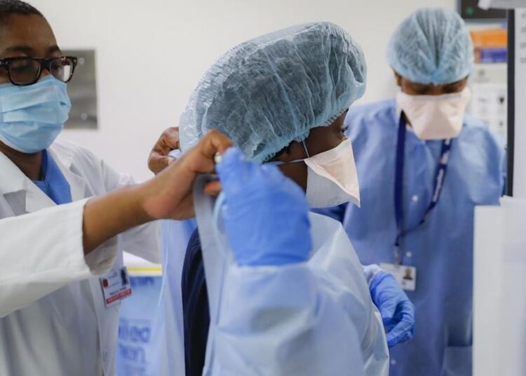 Medical personnel adjust their personal protective equipment while working in the emergency department at NYC Health Hospitals Metropolitan in New York.