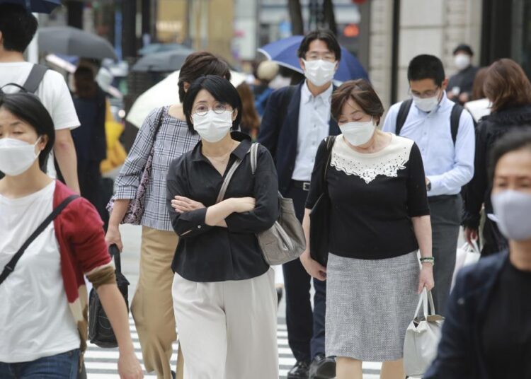 Japan extends virus emergency until end of September 1 - Egyptian Gazette People wearing face masks to protect against the spread of the coronavirus walk on a street in Tokyo on Wednesday, September 8, 2021.