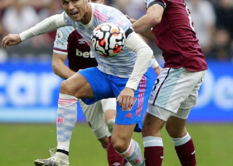 Manchester United's Cristiano Ronaldo goes for the ball as West Ham's Pablo Fornals tries to stop him during their English Premier League match.