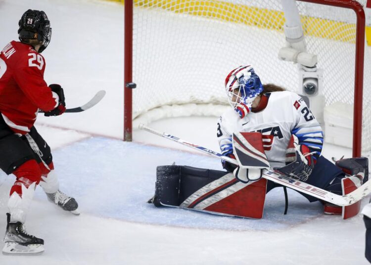 A shot by Canada's Marie-Philip Poulin, left, hits the post as U.S. goalie Nicole Hensley looks back during the third period of the IIHF hockey women's world championships title game in Calgary, Alberta.