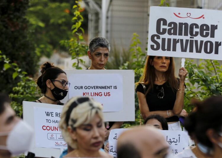 A file photo of cancer patients and supporters holding placards during a sit-in to protest shortages in medications, in front of the UN headquarters in Beirut.