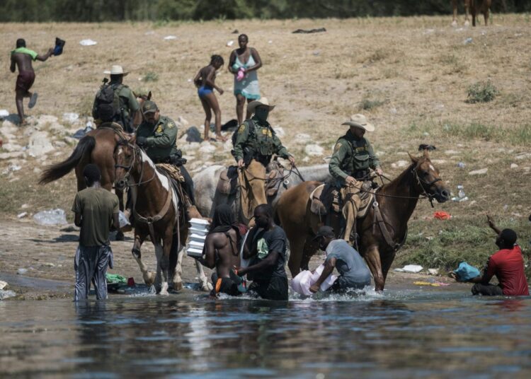 US Customs and Border Protection mounted officers attempt to contain migrants as they cross the Rio Grande from Ciudad Acuna, Mexico, into Del Rio, Texas, on Sept. 19, 2021.
