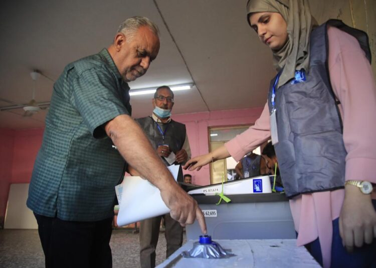 An Iraqi man dips his finger in ink after voting at a polling center during parliamentary elections in Baghdad, Iraq, Sunday, Oct. 10, 2021.