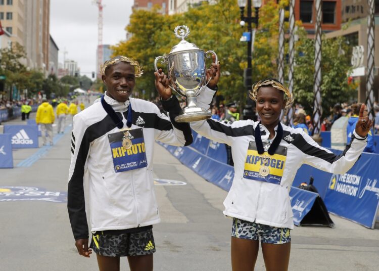 Benson Kipruto (L) and Diana Kipyogei, both of Kenya, celebrate winning the men's and women's divisions of the 2021 Boston Marathon.