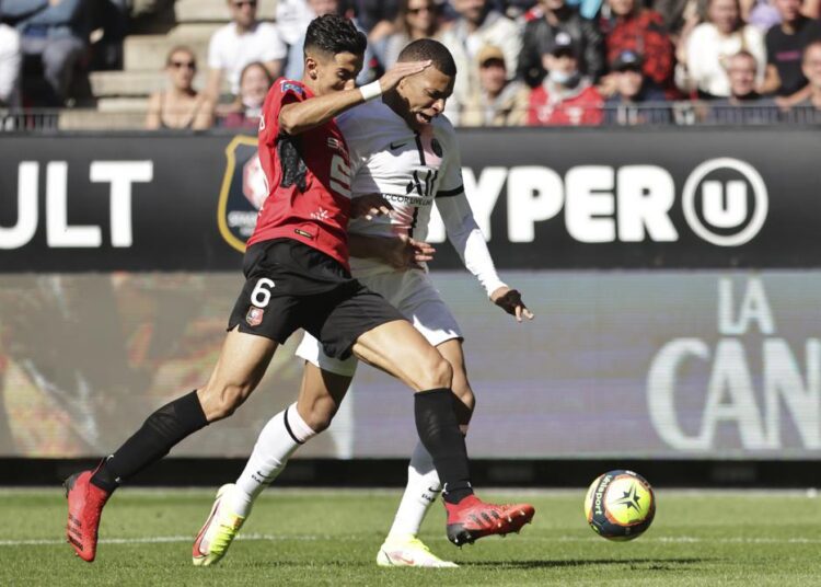 PSG's Kylian Mbappe (R) is challenged by Rennes' Nayef Aguerd during the French League One match in Rennes.