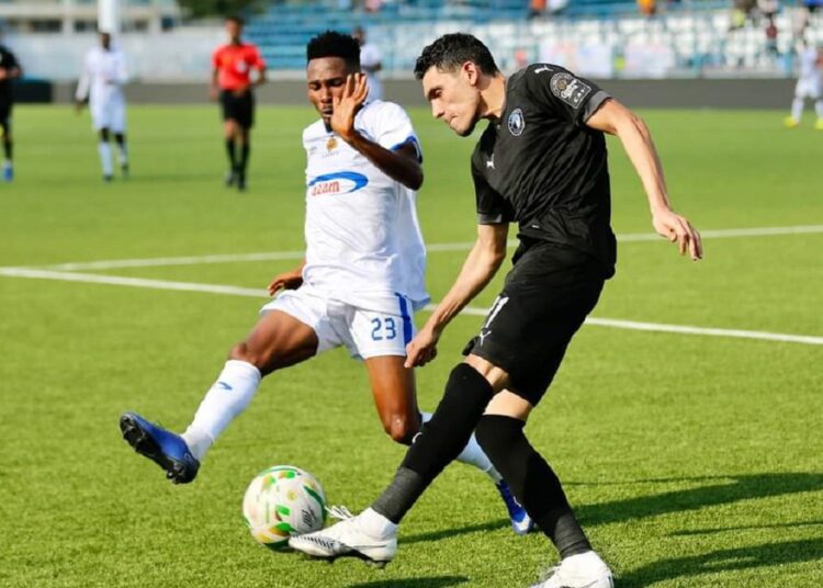 Egypt’s Pyramids Mohamed Hamdi (R) vying for the ball against Tanzanian Azam player.