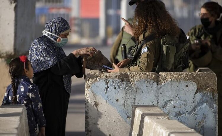 Israeli soldiers check a Palestinian woman as she waits to cross the Qalandiya checkpoint between the West Bank city of Ramallah and Jerusalem, to attend the second Friday prayers in the al-Aqsa mosque during the Muslim holy month of Ramadan on April 23, 2021. (AP)
