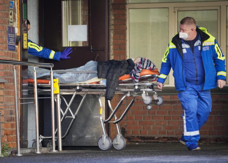 Medical workers carry a patient suspected of having coronavirus on a stretcher at a hospital for COVID-19 patients in St. Petersburg, Russia, on Oct. 29, 2021.