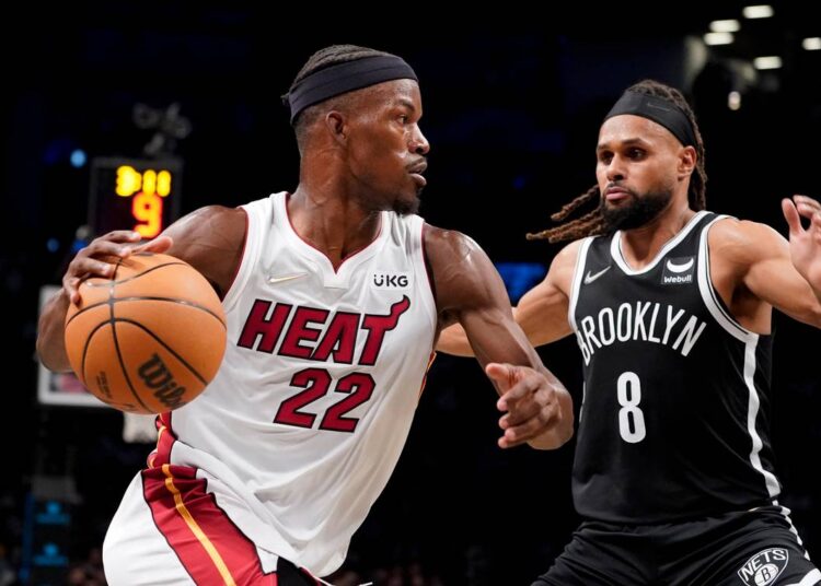 Miami Heat Jimmy Butler (L) drives to the net against Brooklyn Nets Patty Mills during the first half of an NBA game in New York.