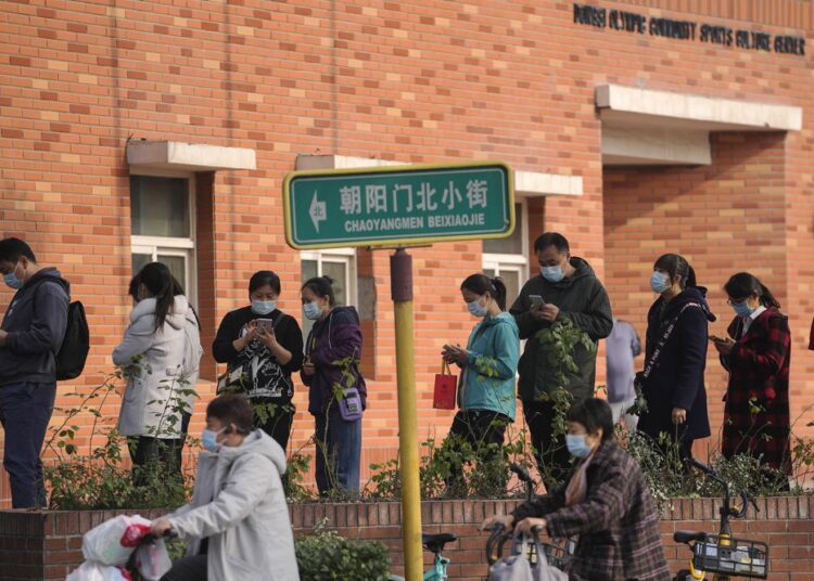 China to start vaccinating children to age 3 as cases spread 1 - Egyptian Gazette Women wearing face masks to help curb the spread of the coronavirus ride scooters passing by masked residents line up to receive booster shots against Covid-19 at a vaccination site in Beijing, Monday, October 25, 2021.