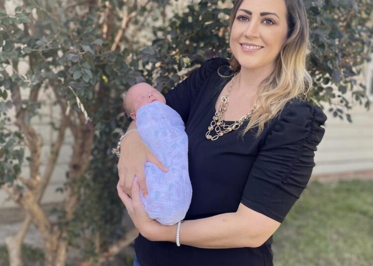 Amanda Harrison holds her baby, Lake,outside her mother's home in Phenix City,Ala., on Monday, October 18, 2021.