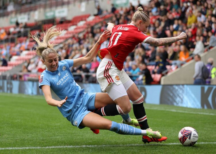 Janine Beckie of Manchester City (L) vying for the ball against Leah Galton of Manchester United.