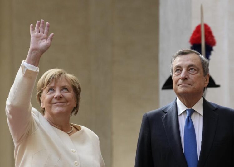 German Chancellor Angela Merkel, left, waves as she arrives for a meeting with Italian Premier Mario Draghi at Palazzo Chigi Premier office, in Rome, Thursday, Oct. 7, 2021.