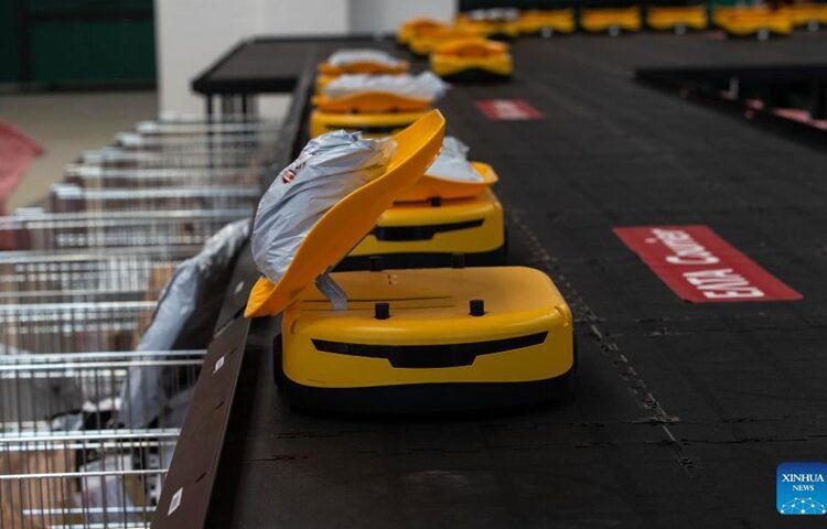A robot drops a parcel in a mail sack at the Hellenic Post's sorting centre in Kryoneri, Greece.