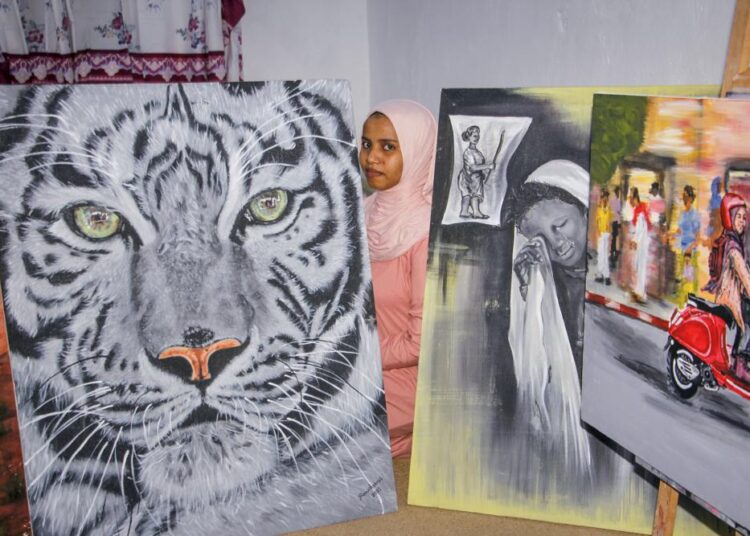 In Somalia, a rare female artist promotes images of peace 1 - Egyptian Gazette Somali artist Sana Ashraf Sharif Muhsin, 21, sits with some of her paintings at her home in the capital Mogadishu, Somalia on October 15, 2021.