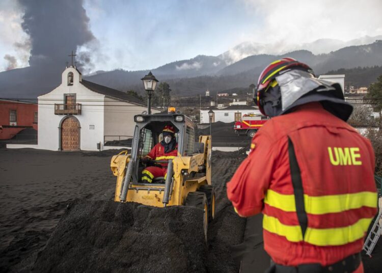 Strongest quake since volcano erupted shakes Spanish island 1 - Egyptian Gazette Military Emergency Unit personal clear black ash from volcano as it continues to erupt lava behind a church on the Canary island of La Palma, Spain on Wednesday October 13, 2021.