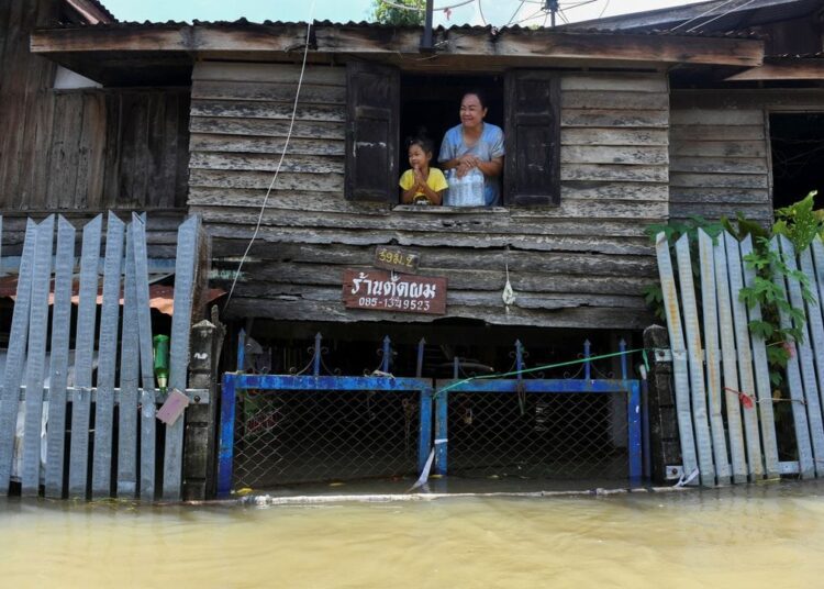 A mother and daughter are seen on the second floor of their house in a flooded area in Ban Sai village, Ban Mi district in Lopburi province, Thailand, September 30, 2021.