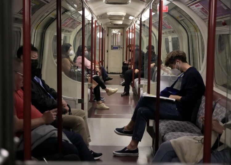 FILE - In this Oct. 4, 2021 file photo, people traveling in a tube underground train carriage wear face masks to curb the spread of coronavirus on the Bakerloo Line in London. Many scientists are pressing the British government to re-impose social restrictions and speed up booster vaccinations as coronavirus infection rates, already Europe’s highest, rise once more. The U.K. recorded 49,156 new COVID-19 cases on Monday, Oct. 18, 2021, the largest number since mid-July. New infections averaged 43,000 a day over the past week, a 15 per cent increase on the week before.