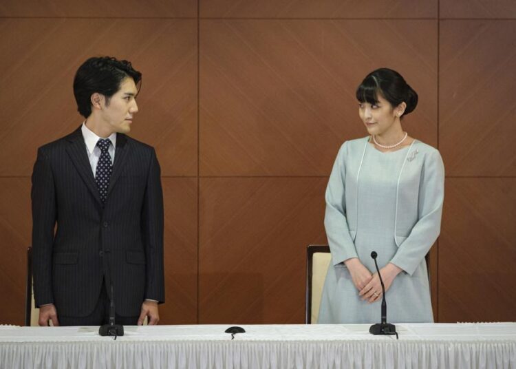 Japan's former Princess Mako, right, the elder daughter of Crown Prince Akishino and Crown Princess Kiko, and her husband Kei Komuro, look at each other during a press conference to announce their marriage at a hotel in Tokyo, Japan Tuesday, Oct. 26, 2021. Former Princess Mako married the commoner and lost her royal status Tuesday in a union that has split public opinion after a three-year delay caused by a financial dispute involving her new mother-in-law.