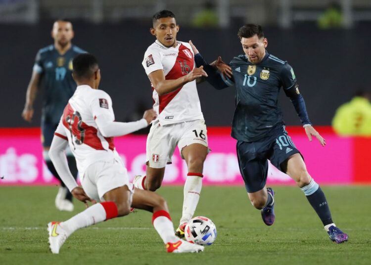 Argentina's Lionel Messi in action with Peru's Christofer Gonzales at Estadio Monumental, Buenos Aires, October 14, 2021.