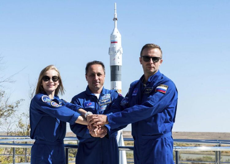 In this handout photo released by Roscosmos, Actress Yulia Peresild, left, director Klim Shipenko' right, and cosmonaut Anton Shkaplerov, members of the prime crew of Soyuz MS-19 spaceship pose at the Russian launch facility in the Baikonur Cosmodrome, Kazakhstan, Monday, Sept. 27, 2021. PIn a historic first, Russia is set to launch an actress and a film director to space to make a feature film in orbit. Actress Yulia Peresild and director Klim Shipenko are set to blast off Tuesday for the International Space Station in a Russian Soyuz spacecraft together with Anton Shkaplerov, a veteran of three space missions.