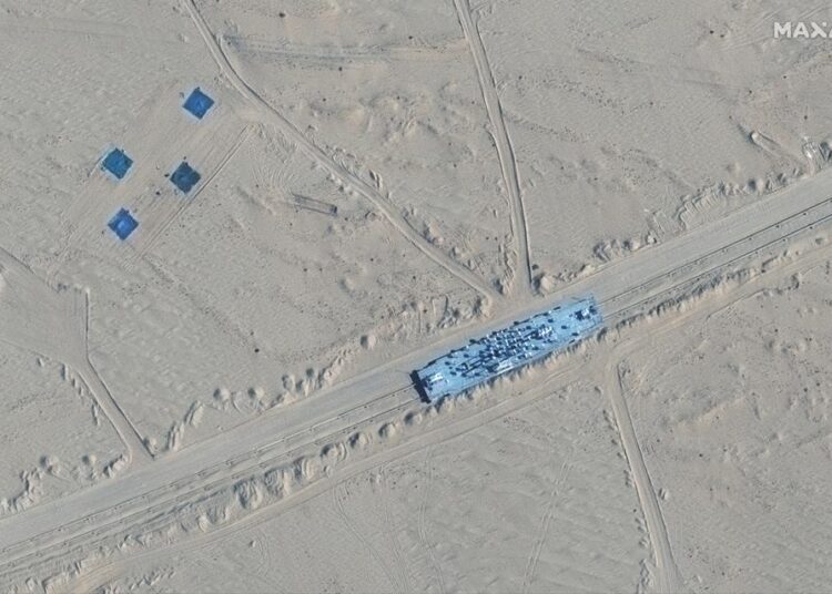 This satellite image provided by Maxar Technologies shows a building on rail tracks in Ruoqiang county, China, Wednesday, Oct. 20, 2021. Satellite images appear to show China has built mock-ups of U.S. Navy aircraft carriers and destroyers in its northwestern desert, such as one at center in this image, possibly as practice for a future naval clash as tensions rise between the nations.