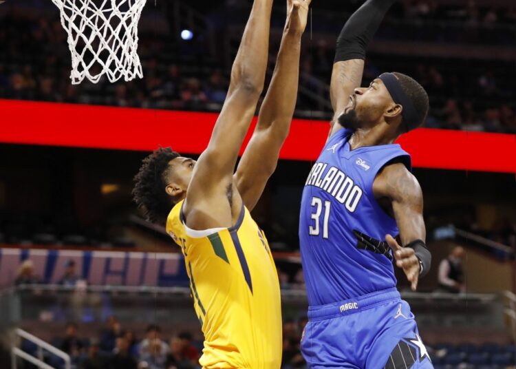 Orlando Magic Terrence Ross tries to drive against Utah Jazz Hassan Whiteside during their NBA game in Orlando, Florida.