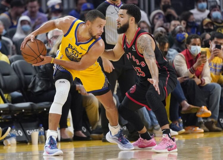 Golden State Warriors guard Stephen Curry (L) is defended by Toronto Raptors Fred VanVleet during their NBA game in San Francisco.