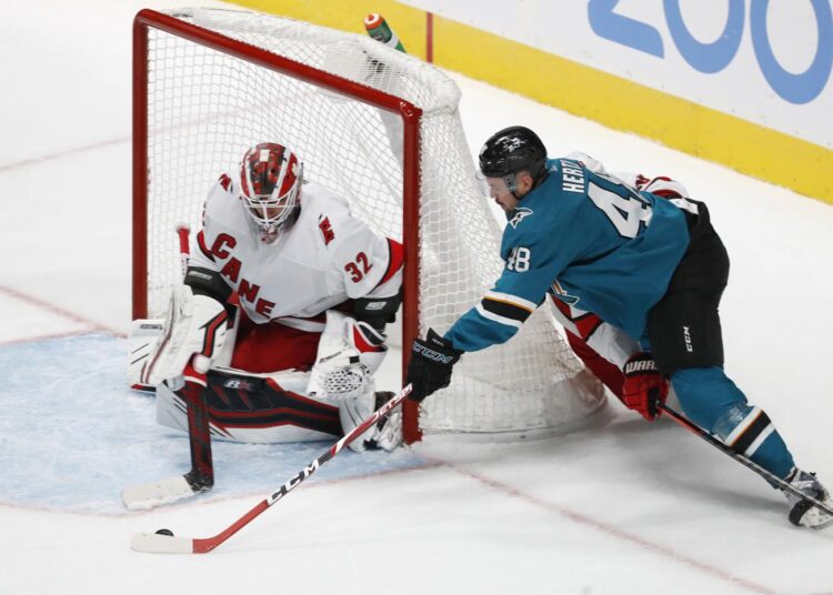 Carolina Hurricanes goaltender Antti Raanta (L) blocks the shot of San Jose Sharks center Tomas Hertl during their NHL game.