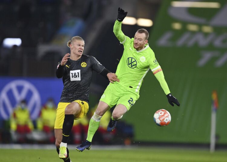 Dortmund's Erling Haaland (L) and Wolfsburg's Maximilian Arnold challenge for the ball during their Bundesliga match in Wolfsburg.
