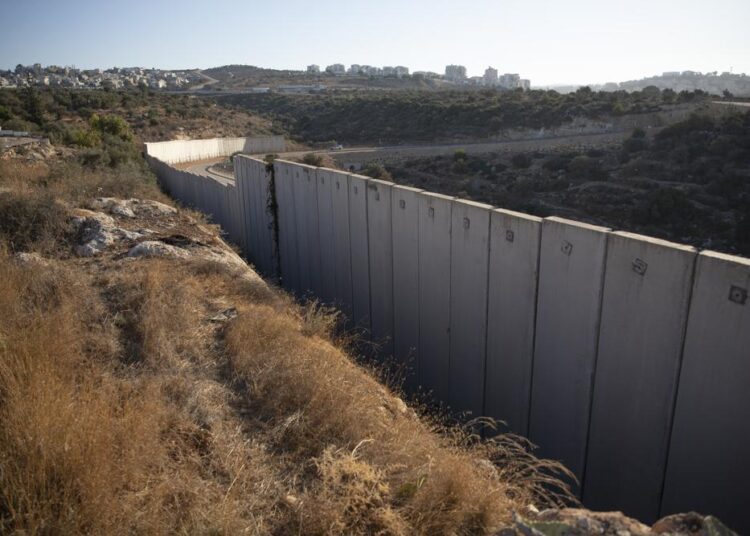 A section of Israel's separation barrier separates between the Israeli settlement of Modi'in Illit, right and the West Bank village of Nilin, west of Ramallah, Sunday, Nov. 7, 2021. Nearly two decades after Israel sparked controversy worldwide by building the barrier during a Palestinian uprising, it has become a seemingly permanent feature of the landscape — even as Israel encourages its citizens to settle on both sides. (AP Photo)