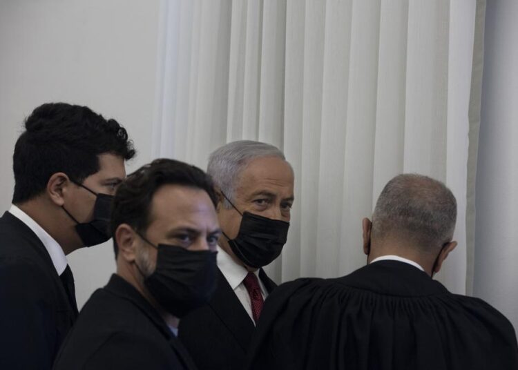 Former Israeli Prime Minister Benjamin Netanyahu, third from left, is flanked by lawyers before testimony by star witness Nir Hefetz, a former aide, in his corruption trial at the District Court in east Jerusalem, Monday, Nov. 22, 2021. (AP Photo/Maya Alleruzzo, Pool)