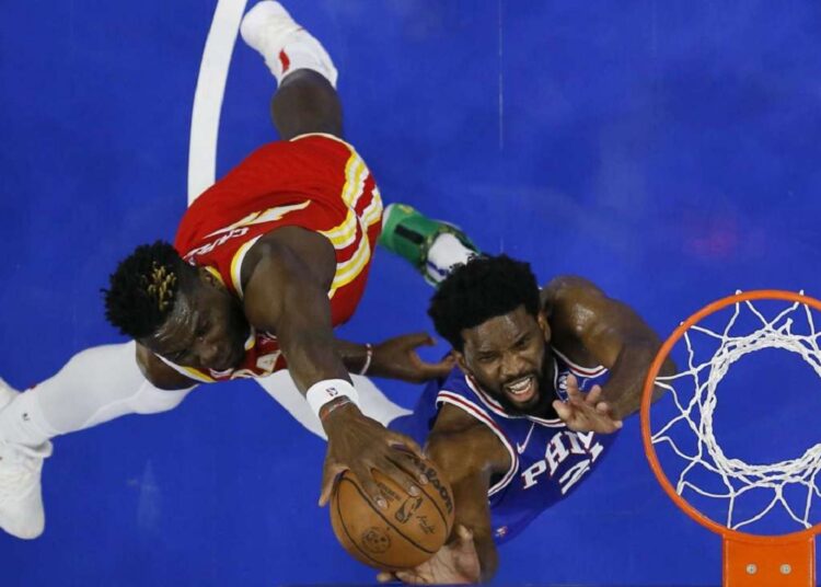 Atlanta Hawks' Clint Capela (L) blocks a shot by Philadelphia 76ers' Joel Embiid during their NBA game in Philadelphia.