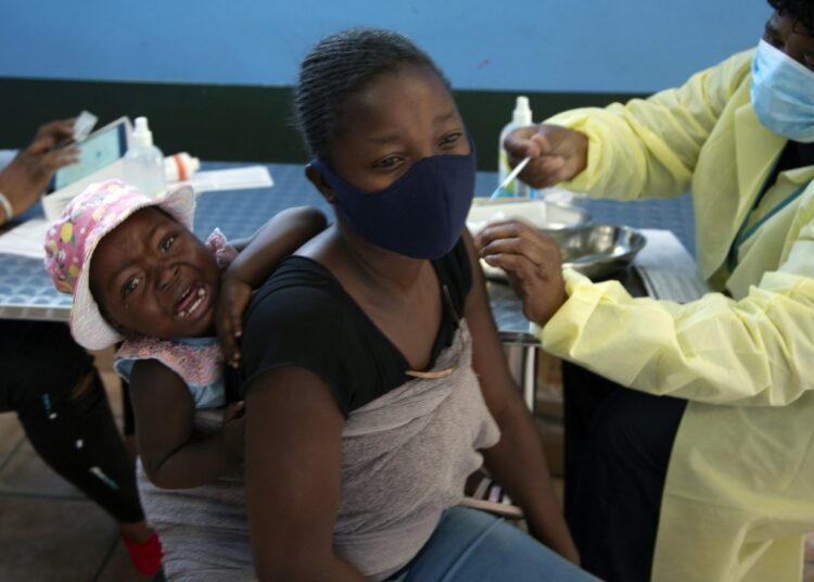 A baby cries as her mother receives her Pfizer vaccine against COVID-19, in Diepsloot Township near Johannesburg Thursday, Oct. 21, 2021.