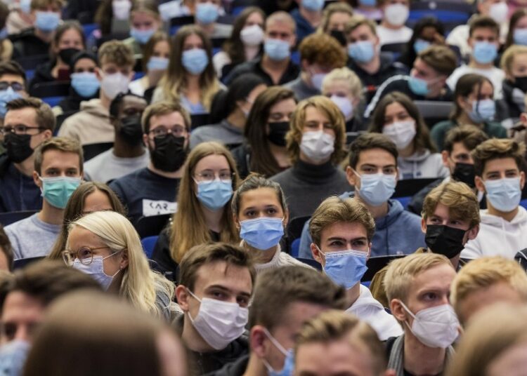 Students wear mouth-to-nose coverings while sitting close to each other during the lecture 'BWL 1' in the Westfaelische Wilhelms-Universitaet in Muenster, Germany, Wednesday, Oct. 21, 2021.