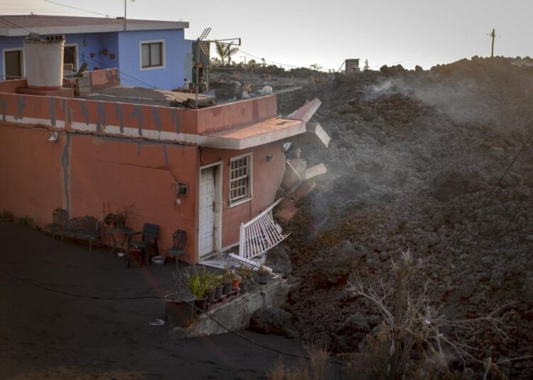 Ash from erupting volcano forces Spanish islanders indoors 1 - Egyptian Gazette Lava from a volcano advances destroying a house as it continues to erupt on the Canary island of La Palma, Spain, on Tuesday, November 2, 2021.