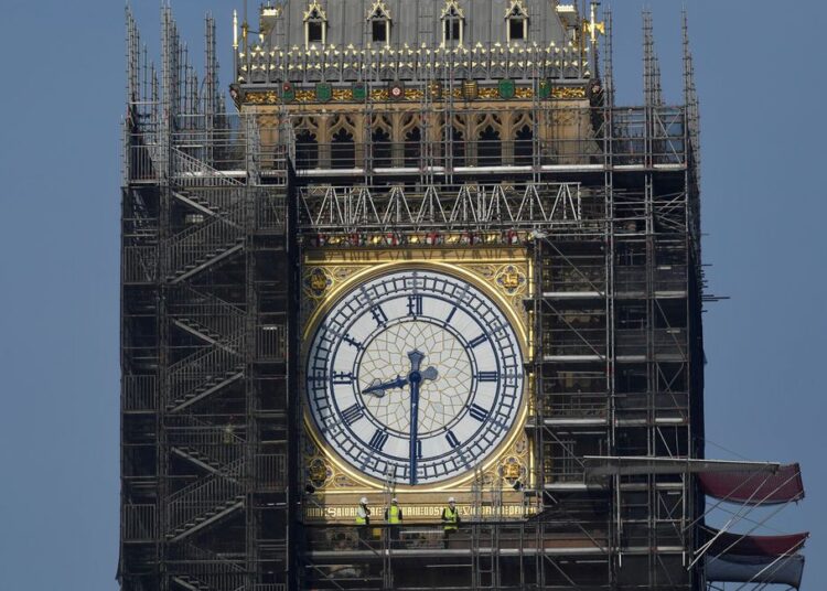 Workers stand on scaffolding underneath one of the clock faces on the Elizabeth Tower, more commonly known as Big Ben, as hands and dials are seen restored to the original Prussian blue colouring, whilst renovation works continue at the Houses of Parliament, London, Britain, September 6, 2021.