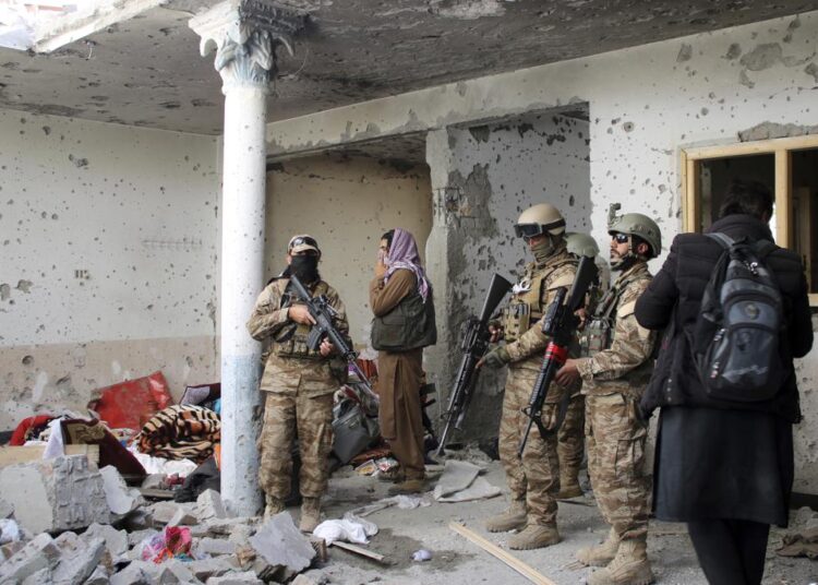 Taliban fighters inspect a house after an 8-hour gunbattle erupted between Taliban and Islamic State group fighters, when Taliban forces raided a suspected hideout of IS militants on the outskirts of Jalalabad, east of Kabul, Afghanistan, Tuesday, Nov. 30, 2021.