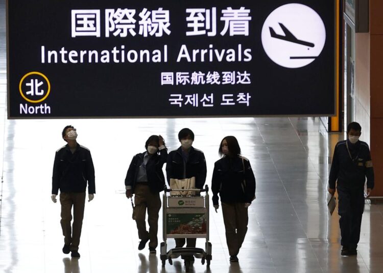 Passengers walk at the lobby for the international arrivals at Kansai International Airport in Osaka, western Japan, Tuesday, Nov. 30, 2021. Japan confirmed on Tuesday its first case of the new omicron coronavirus variant, a visitor who recently arrived from Namibia, an official said.