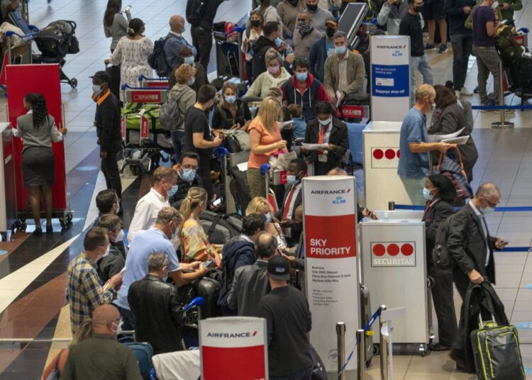 World scurries to contain new Covid variant 1 - Egyptian Gazette People queue to get on the Air France flight to Paris at OR Tambo's airport in Johannesburg, South Africa, Nov. 26, 2021.