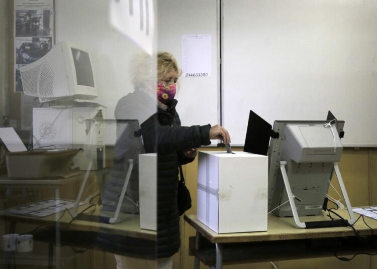 A woman casts her vote in a polling station in Sofia, Sunday, Nov. 21, 2021. Voters go to the polls in Bulgaria for the forth time in seven months this weekend to elect a new president. A runoff election will elect a new president as none of the candidates received enough ballots to win the first round of polls on Nov. 14.