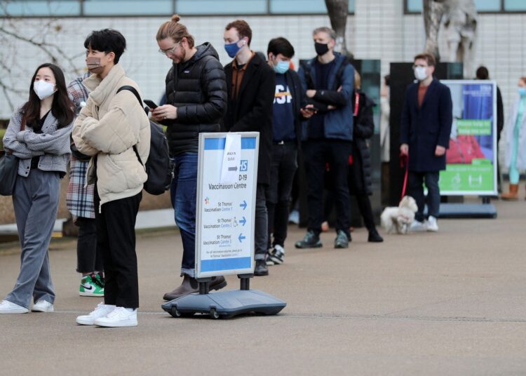 First death with Omicron variant in United Kingdom 1 - Egyptian Gazette People queue outside a coronavirus disease (COVID-19) vaccination centre at St Thomas' Hospital as the pandemic continues, in London, Britain, December 12, 2021.
