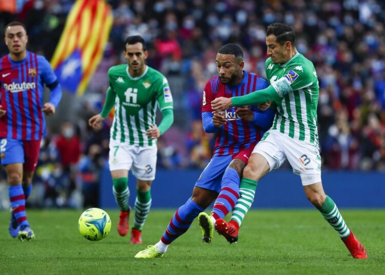 Real Betis' Andres Guardado (R) vies for the ball with Barcelona's Memphis Depay during La Liga match in Barcelona.